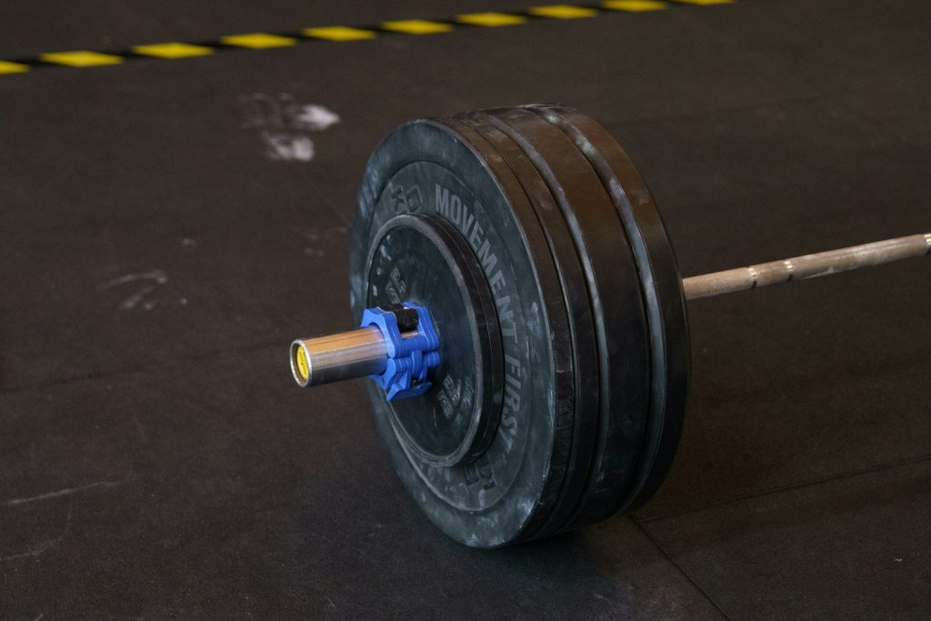A barbell rests on the ground, ready for use.